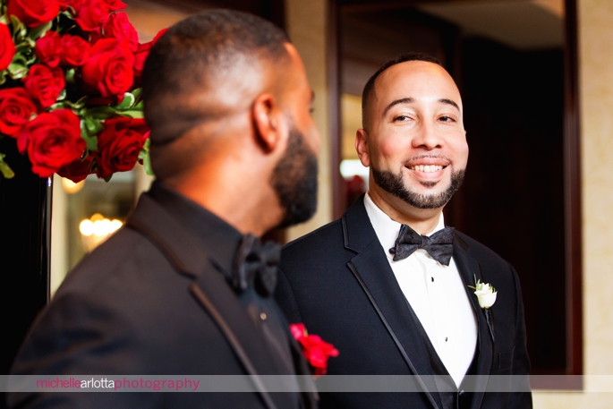 best man looks at groom during indoor wedding ceremony at Nassau Inn in Princeton, New Jersey photographed by michelle Arlotta photography
