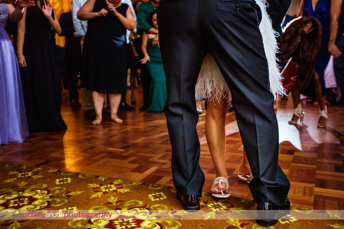 bride wearing short feather dress with flip flops during Nassau Inn Wedding reception in Princeton NJ photographed by michelle Arlotta photography