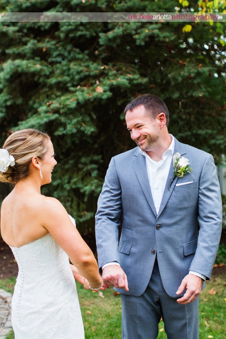 groom in grey suit turns around to see bride during first look