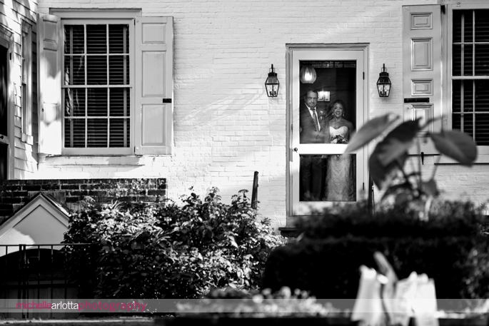 bride and her father watch from procession from inside the haddonfield historical gardens building