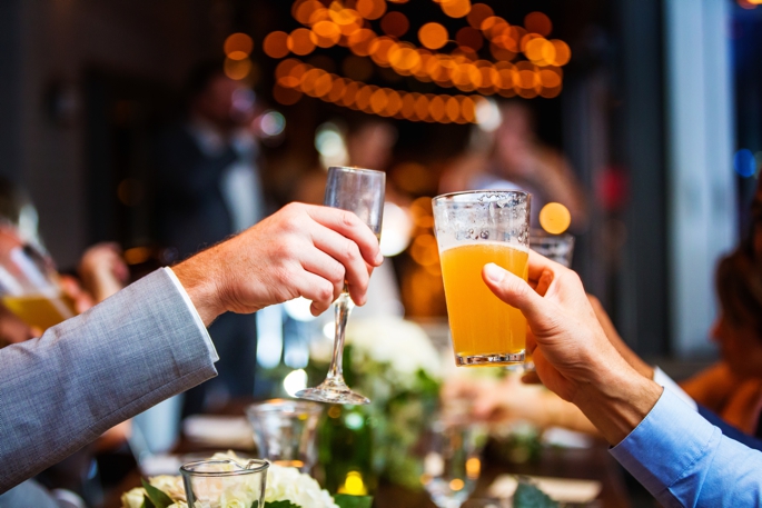 champagne and beer glasses toasting during intimate New Jersey wedding at the treno pizza bar in vestment