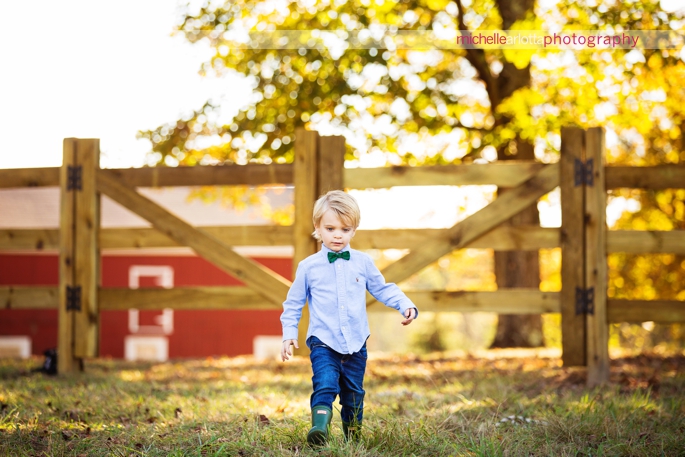 toddler with bowtie and hunter boots candid family photography session in Bedminster, New Jersey