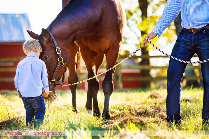 toddler feeds his horse during candid family photography session in New Jersey