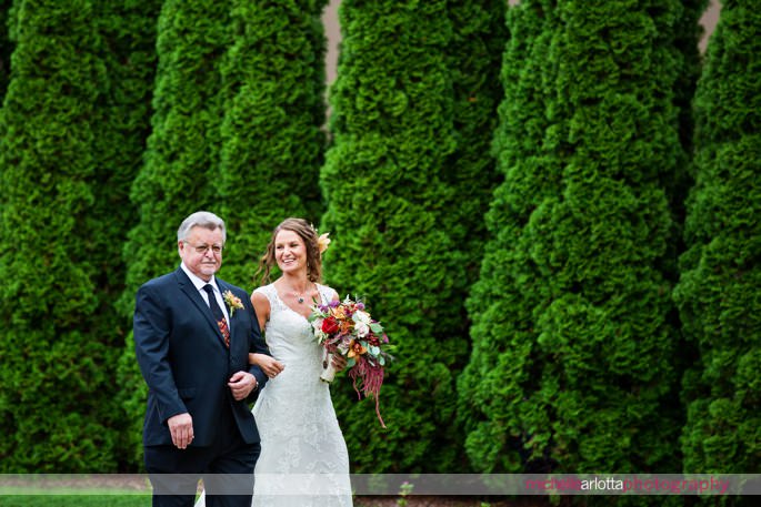 bride walks to the ceremony area with her father at outdoor fall rock island lake club wedding