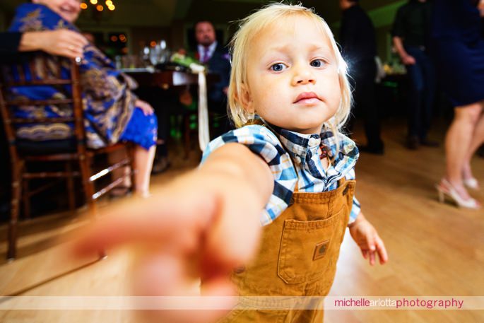 little boy in overalls tried to touch camera lens during rock island lake club wedding reception