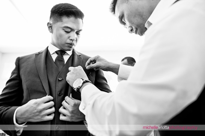 groomsmen helps groom with pocket square for Monmouth county nj wedding