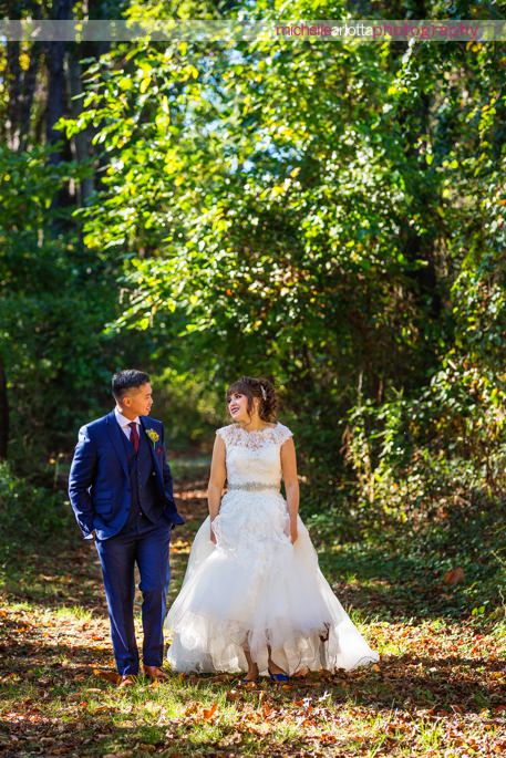 bride in 3graces bridal wedding gown and groom in suit with maroon detailing walk during portraits at battleground country club photographed by nj wedding photographer michelle Arlotta