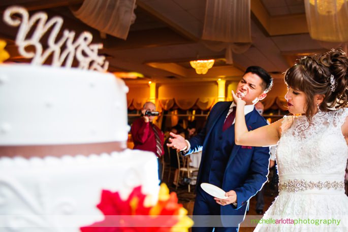 bride shoves cake in groom's face at battleground country club wedding reception with Michelle Arlotta photography