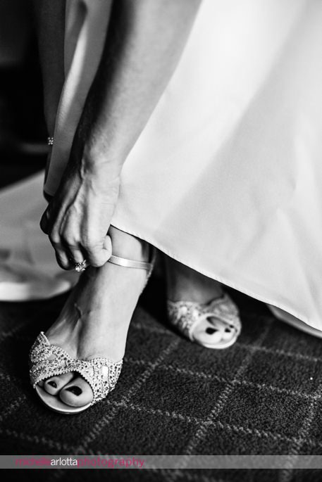 bride puts on her badgley mischka wedding heels