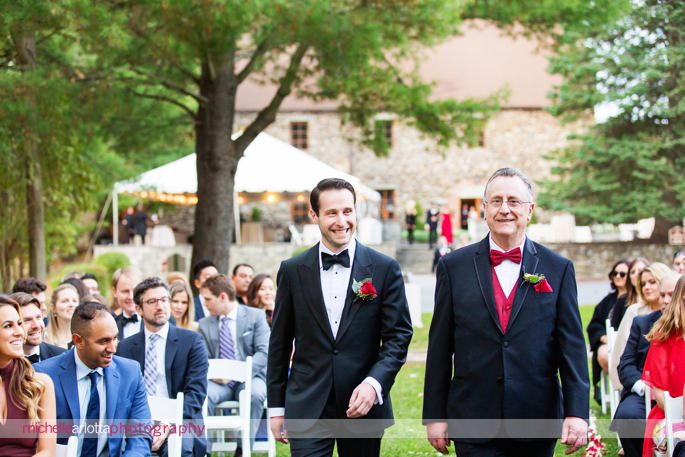 groom and father walk down the aisle in tuxedos for outdoor wedding ceremony at brother winery