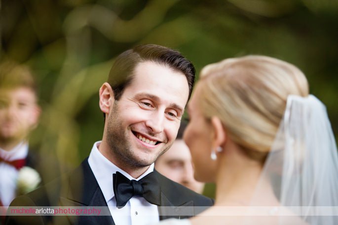 groom in tux smiles and looks at bride outdoor fall wedding ceremony at brotherhood winery photographed by Hudson valley wedding photographer michelle arlotta