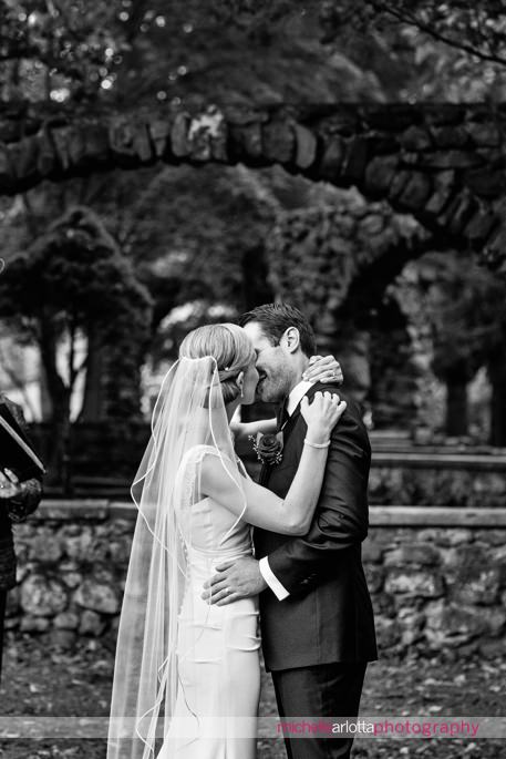 bride and groom kiss at end of outdoor wedding ceremony at brotherhood winery photographed by Hudson valley wedding photographer michelle arlotta
