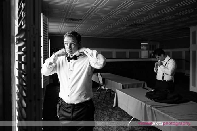 groom puts on bow tie