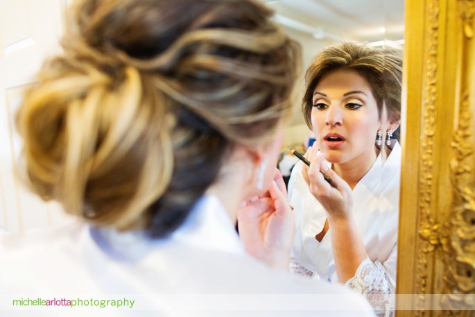 bride puts on lipstick in mirror