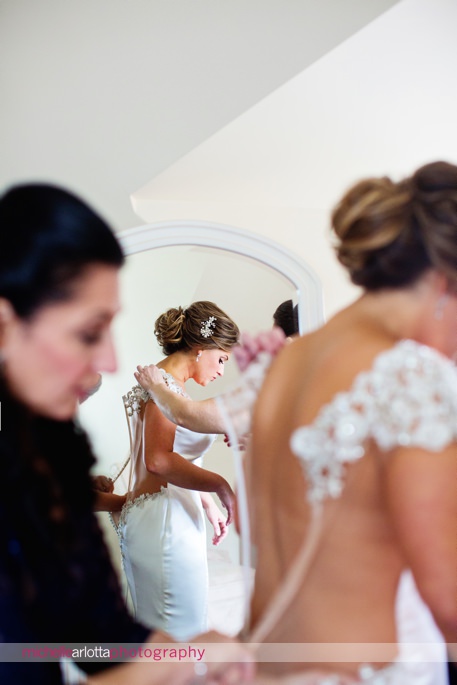 bride is helped by mother and sister getting in jahee bridal atelier wedding gown