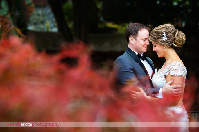 bride and groom among bright red foliage during their fall lake mohawk wedding