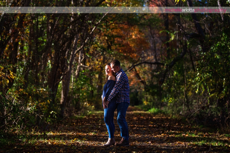 couple embracing in dramatic light during fall engagement session in hunterdon county New Jersey
