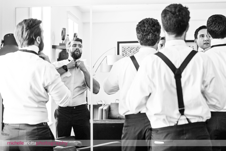 groomsmen tying bowties in mirror in Ryland inn's Pelham house
