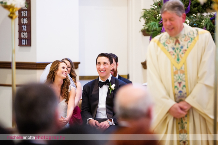 bride and groom laugh during wedding ceremony at st. Elizabeth Ann seton three bridges church