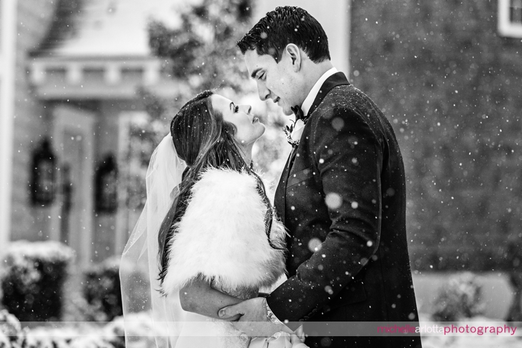 bride and groom at Ryland inn coach house silo in background during snowstorm