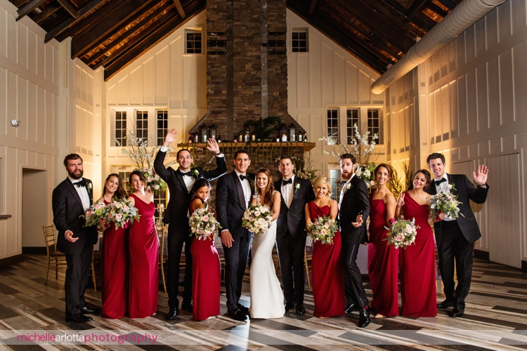 bridal party dressed in red bridesmaid dresses and groomsmen in tuxedos at Ryland inn coach house winter wedding