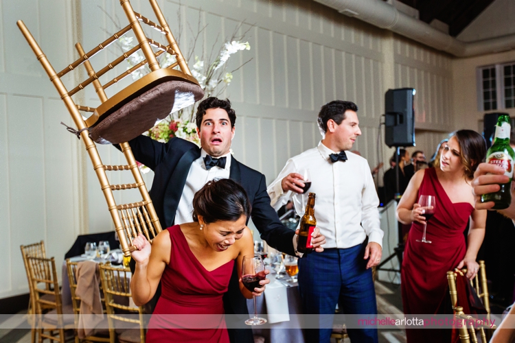 wedding guest holds chair over bridesmaid's head at Ryland inn wedding in New Jersey