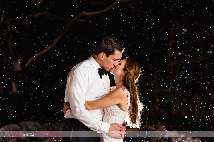bride and groom kiss during snowy nightshot at their Ryland inn coach house winter wedding photographed by New Jersey wedding photographer michelle arlotta