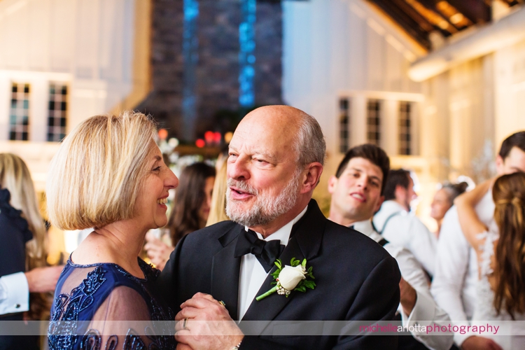 parents of the groom slow dance among guests at Ryland inn coach house winter wedding