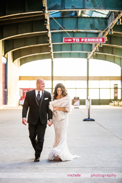 bride in Stephen yearick wedding gown and groom walk in jersey city train station