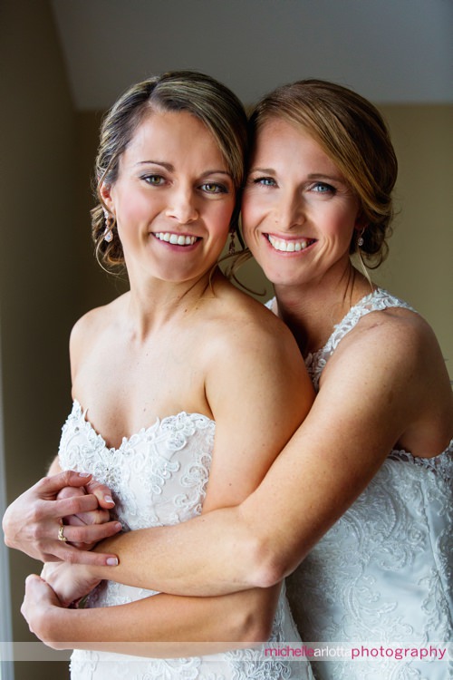 two brides hug one another for portrait on wedding day at rock island lake club