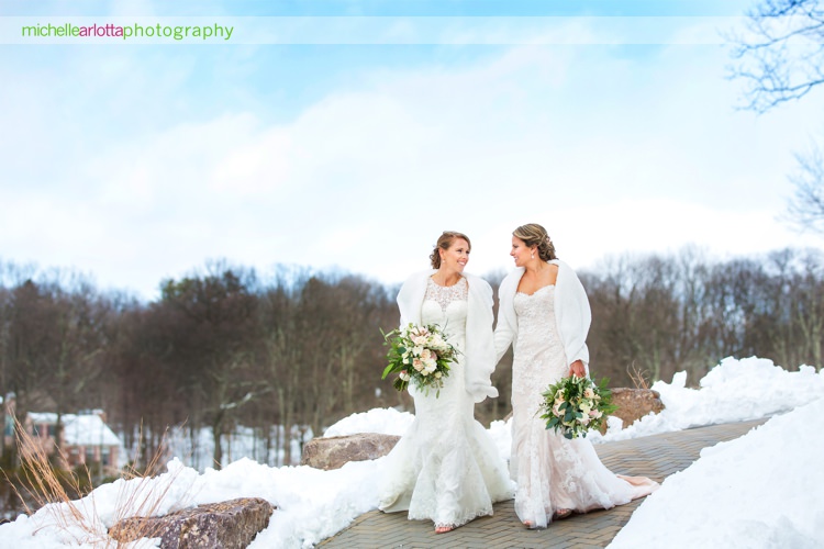 brides with white shawls walk together on cold day at rock island lake club in Sparta, New Jersey