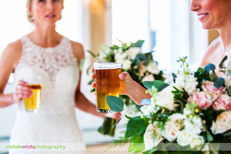 Irish brides hold pints of beer and bouquets for Irish brides at st Patrick's day wedding at rock island lake club