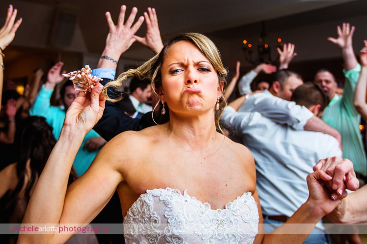 bride makes funny face as her hairpiece falls out of her hair during rock island lake club wedding reception