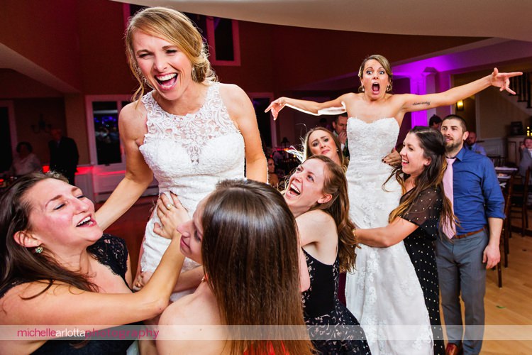 brides hoisted up into the air during same sex rock island lake club winter wedding reception with dj Paul Knox