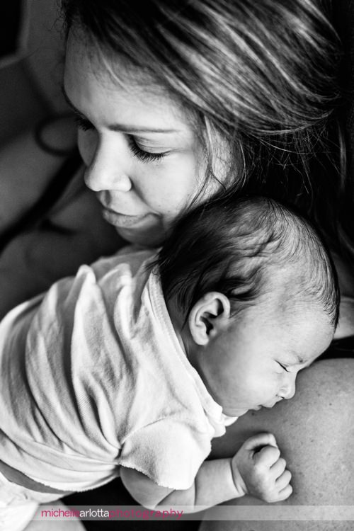 newborn baby girls sleeps soundly on mother's shoulder during newborn lifestyle shoot with New Jersey photographer Michelle arlotta