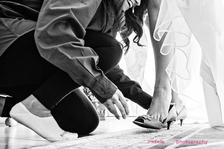 maid of honor helps nj bride put on shoes