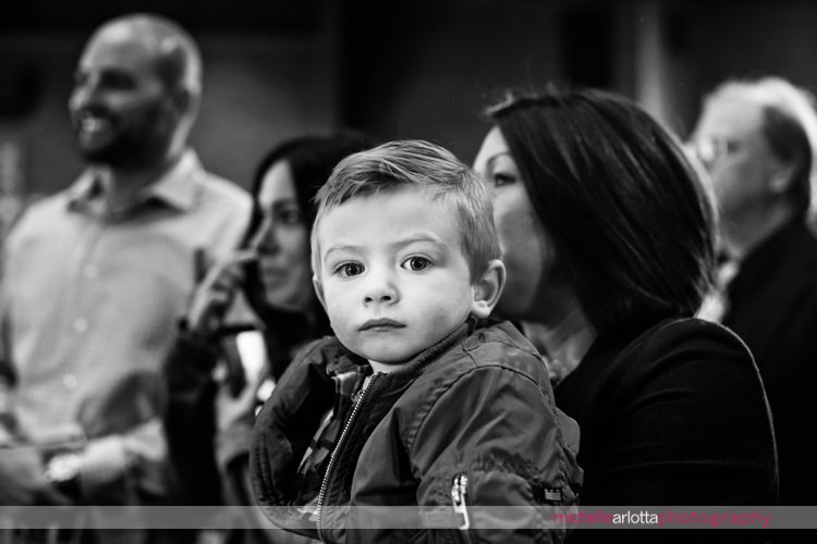 little boy looks straight into camera during wedding ceremony at St Charles Borromeo Church in skillman, NJ