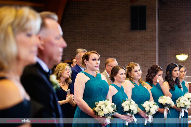 bridesmaids in turquoise bridesmaid dressed stand during wedding ceremony at St Charles Borromeo Church in skillman, NJ