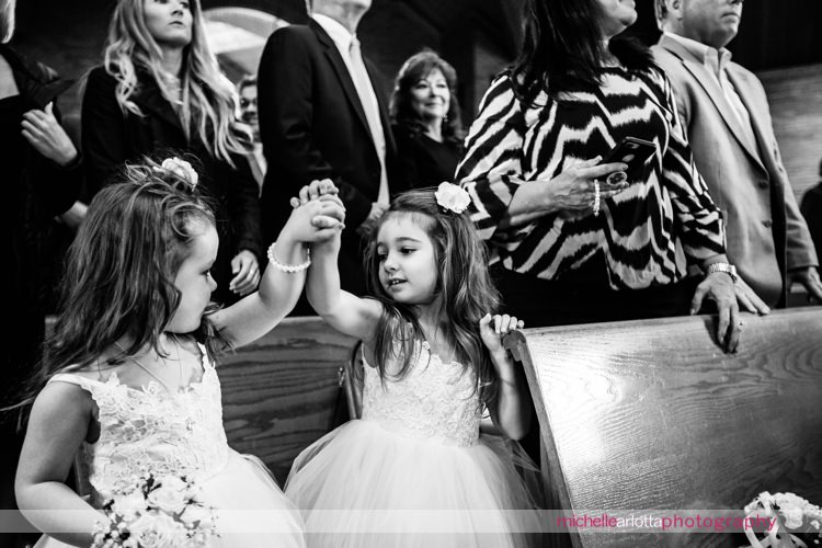 flower girls hold hands during wedding ceremony at St Charles Borromeo Church in skillman, NJ