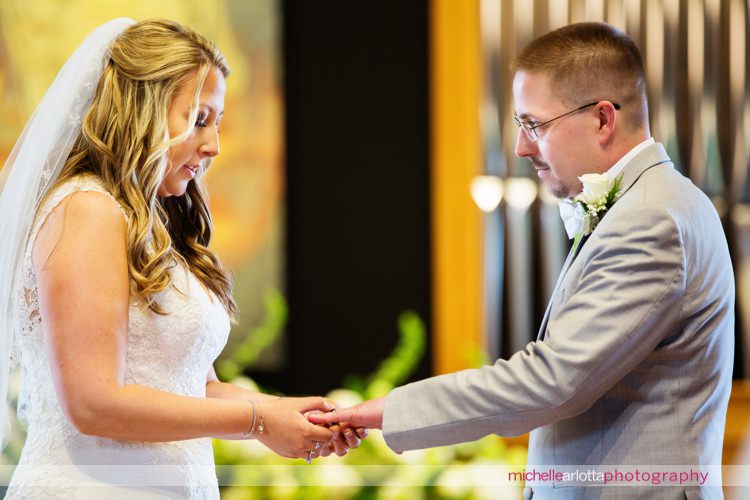 bride and groom exchange rings during wedding ceremony at St Charles Borromeo Church in skillman, NJ