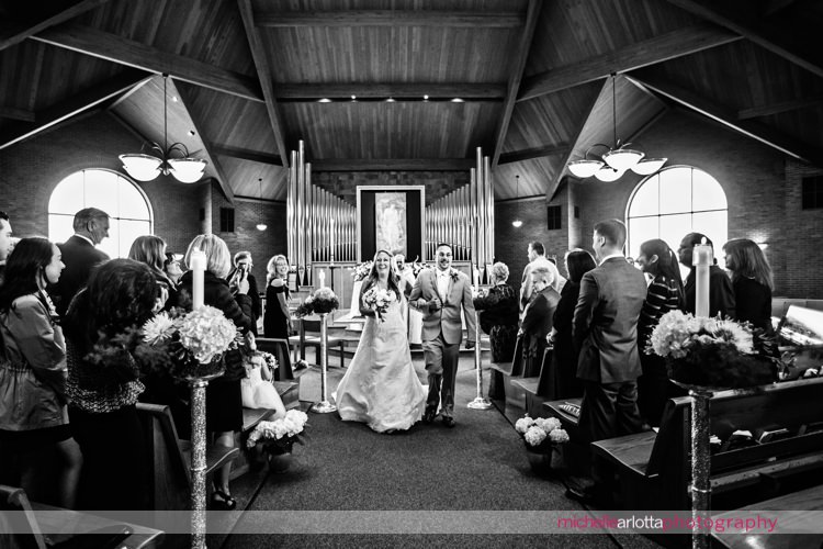 bride and groom exit wedding ceremony wedding ceremony at St Charles Borromeo Church in skillman, NJ