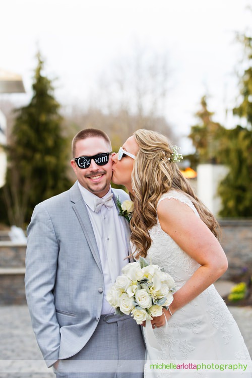 grand marquis in old bridge, new jersey bride kissing groom with groom sunglasses on
