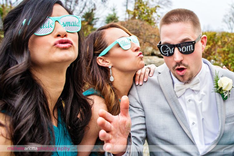 bridesmaids in bridesmaid sunglasses make kissy faces at groom in groom sunglasses for nj wedding