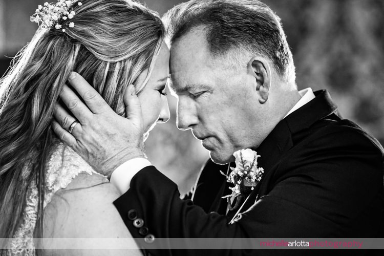 father holds his daughter's face and goes forehead to forehead with her during emotional father daughter dance at nj grand marquis wedding