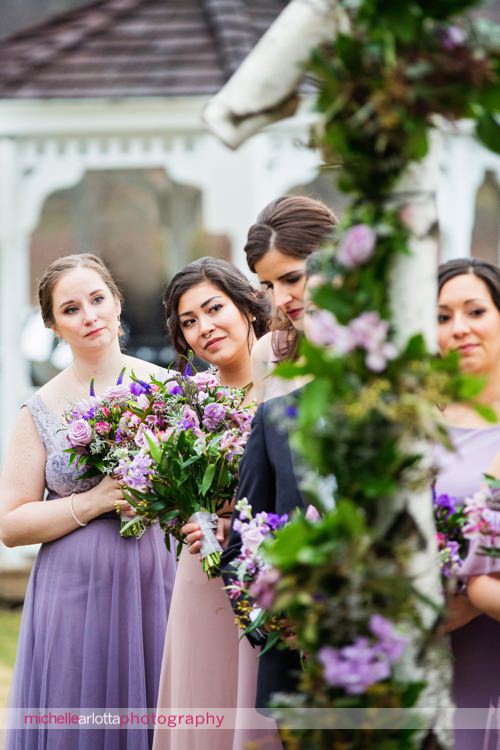 bridemaids in shades of purple brideside bridesmaid dresses watch outdoor wedding ceremony at rock island lake club