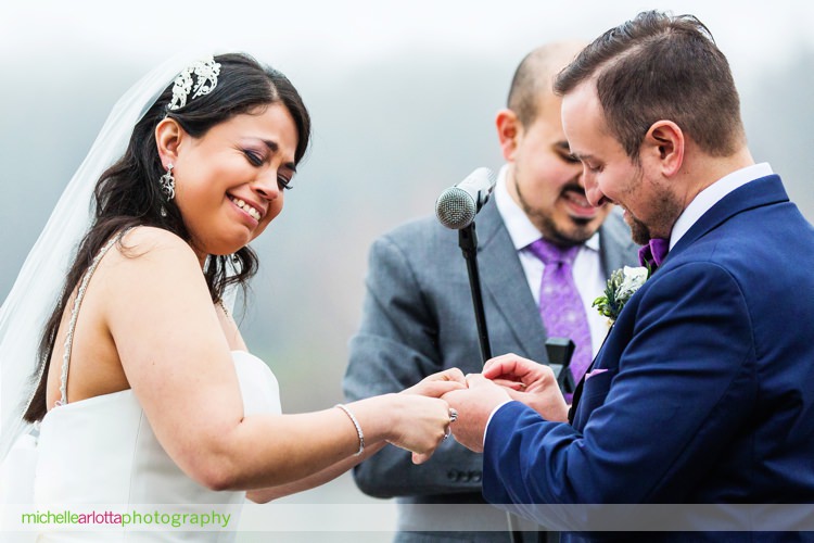 bride laughs as groom realized he started putting wedding ring on the wrong hand
