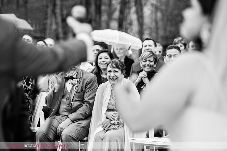 wedding guests laugh at outdoor spring wedding ceremony