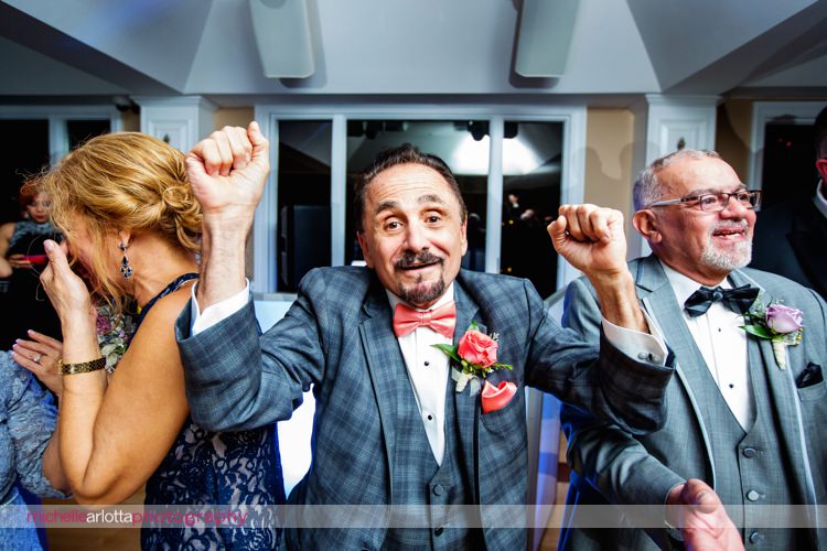 father of the bride cheers as bride and groom enter nj wedding reception