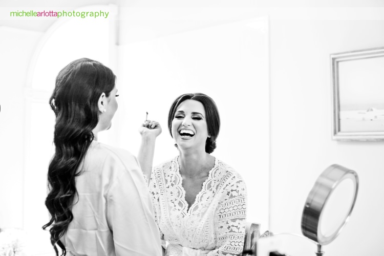 nj bride in lace robe laughs while make up is applied