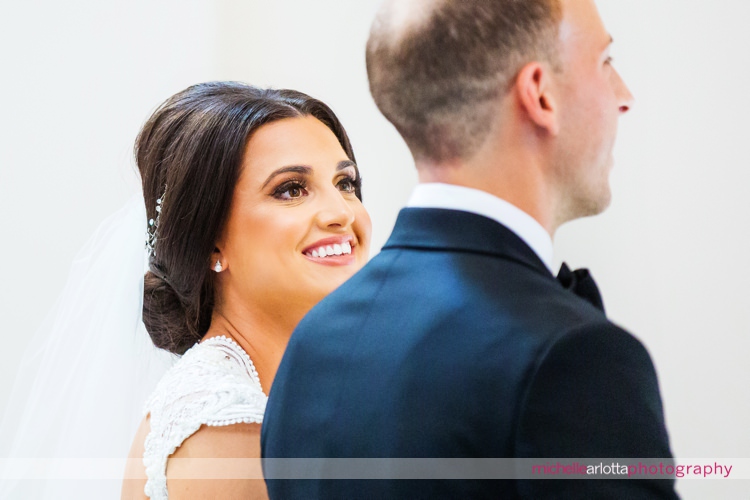 bride smiles and looks to groom during nj wedding ceremony